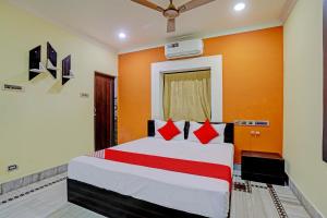 1 dormitorio con 1 cama grande y paredes de color naranja en Flagship VENTURE INN GUEST HOUSE en Bhubaneshwar