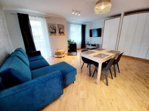 a living room with a blue couch and a table at Kolory Warmii Apartament Niebieski in Olsztyn
