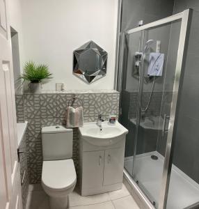 a bathroom with a shower and a toilet and a sink at The Vicarage in Sunderland