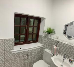 uma casa de banho com um WC, um lavatório e uma janela em The Vicarage em Sunderland