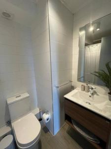 La salle de bains blanche est pourvue de toilettes et d'un lavabo. dans l'établissement Acogedor departamento, à Puerto Varas