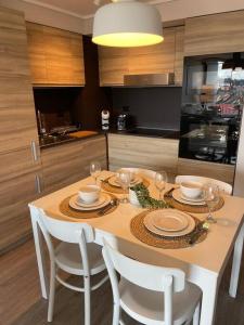 una cocina con una mesa con platos y copas de vino en Acogedor departamento, en Puerto Varas