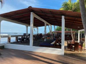 a pavilion with a hammock on the beach at SOLID Surf Camp Hostel Nicaragua in Transito