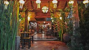 um restaurante com mesas, cadeiras e plantas em Green Tiger House em Chiang Mai