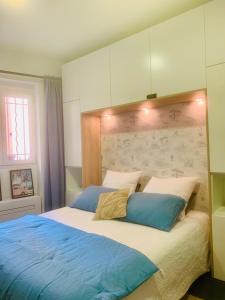 Un dormitorio con una cama grande con almohadas azules. en Les 6 Phocéens, en Marsella
