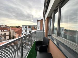 a balcony with two chairs and a view of a city at Sky Apartments 511 in Plzeň