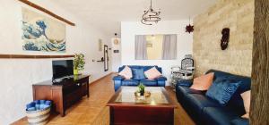 a living room with a blue couch and a tv at Salema Sardina, mar, relax y atardecer in Las Palmas de Gran Canaria