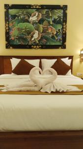 D'Natha Villa Ubud في أوبود: سرير بجعتين مصنوعة من المناشف