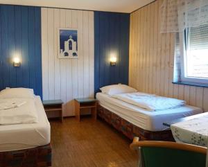 two beds in a room with blue walls at Pension-zur-Rose in Schönaich