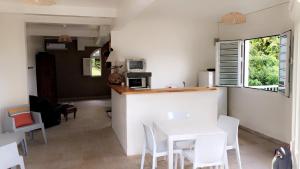 a kitchen and dining room with a white table and chairs at Appartement Topaze in La Trinité