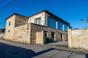 Un grand bâtiment en pierre avec un balcon est disponible. dans l'établissement Casa Antigo Alambique, à Santa Cruz do Lima