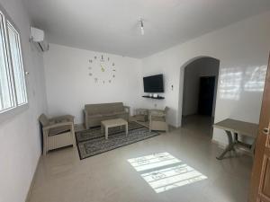 a living room with a couch and a clock on the wall at Villa Medenine in Medenine