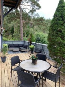 a patio with a table and chairs on a deck at Leilighet i Hagavik 