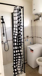 a bathroom with a black and white shower curtain at Appartement Topaze in La Trinité