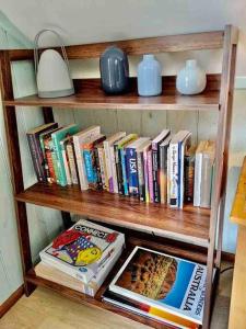 a wooden book shelf filled with books and a lamp at Alyeska Loft - Apollo Bay studio loft apartment in Apollo Bay