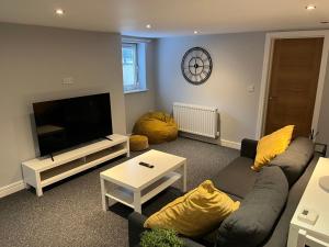 a living room with a couch and a flat screen tv at Stylish 1 Bedroom, 2 bed Basement Flat With Free Parking in Sale