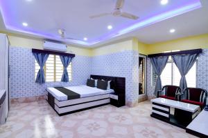 Super OYO Anandalok Guest House في كولْكاتا: غرفة نوم فيها سرير وكرسيين