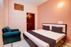 a bedroom with a bed and a blue chair at OYO Home Tilak Hotel 24 in Noida