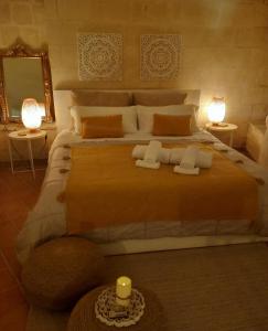 a bedroom with a large bed with two candles on it at Dimora 1919 Luxury Loft in Matera