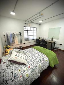 ein Schlafzimmer mit einem Bett mit einer grünen Decke in der Unterkunft Idea Home in Lima