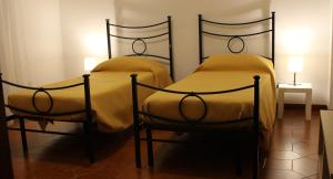 two twin beds in a room with two lamps at Camera a Grammichele in Grammichele