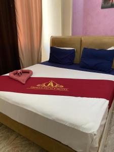1 cama con manta roja y blanca y almohadas azules en ABDEEN HOSTEL en El Cairo