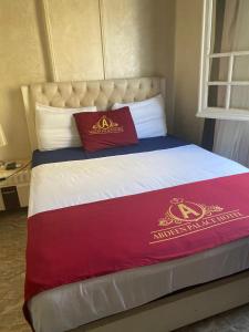 uma cama com duas almofadas vermelhas em cima em ABDEEN HOSTEL no Cairo