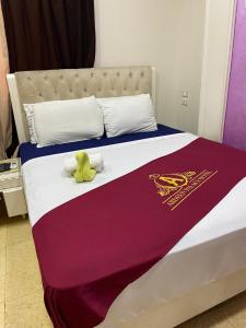 Una cama grande con una manta roja y morada. en ABDEEN HOSTEL en El Cairo