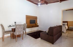 a living room with a table and a chair and a couch at Villa Sunset in Arraial d'Ajuda