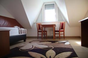 a bedroom with a bed and a table and chairs at Auguszta Hotel és Diákszálló in Debrecen