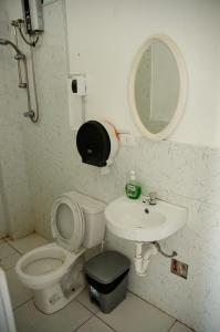 ein Badezimmer mit einem WC, einem Waschbecken und einem Spiegel in der Unterkunft Ugarte Street in Trujillo