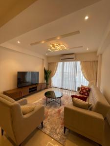 a living room with two couches and a flat screen tv at Solaris Appartment 5&7th floor in Accra