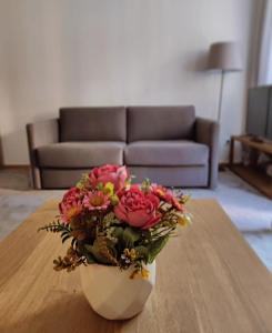un jarrón lleno de flores sentado en una mesa en Gondola Studio Brzeće Kopaonik en Brzeće
