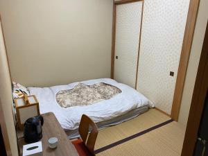 Kleines Zimmer mit einem Bett und einem Tisch in der Unterkunft Gora Onsen Kinkaku 金閣莊 預約制免費個人湯屋 Private onsen free by Reservation in Hakone