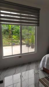 a bedroom with a window with a view of a yard at Un Lugar para soñar in La Maná