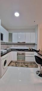 a kitchen with white cabinets and a washer and dryer at SUITES-HOME, CIDADELA in Praia