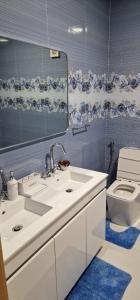 a bathroom with a sink and a toilet and a mirror at SUITES-HOME, CIDADELA in Praia