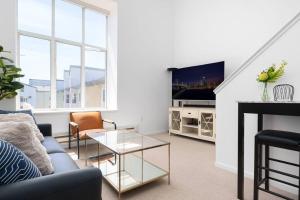 ein Wohnzimmer mit einem Sofa und einem TV in der Unterkunft Modern Loft in Mission / Hayes Valley with Parking in San Francisco