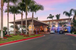 a hotel with palm trees in front of a building at Best Western Plus Marina Gateway Hotel in National City