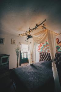 a bedroom with a bed with a canopy at Hostal Casa del Frailejón - Café in Monguí