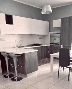 uma cozinha com armários brancos, um lavatório e uma mesa em Appartamento nel cuore di Aosta em Aosta