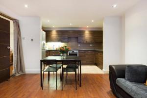 a kitchen and living room with a table and chairs at Harrods Flats in London