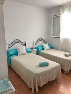 Duas camas num quarto com almofadas azuis em APT CalmaCabana a 50m dal mare em Es Pujols
