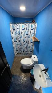 niebieska łazienka z toaletą i umywalką w obiekcie Villa Kataleya w mieście Dominical