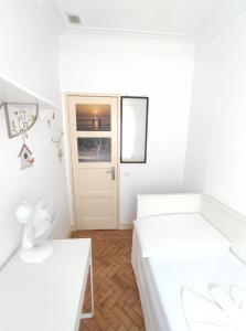 a white bedroom with two beds and a door at Memo Moscavide Guest House in Lisbon