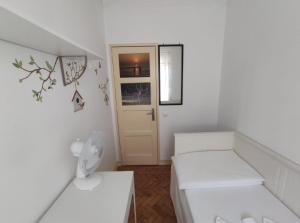 um pequeno quarto branco com uma cama e uma porta em Memo Moscavide Guest House em Lisboa
