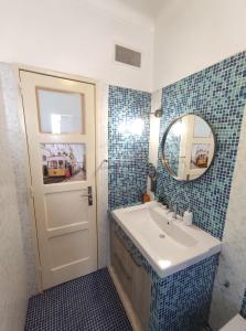 uma casa de banho com um lavatório, um espelho e uma porta em Memo Moscavide Guest House em Lisboa