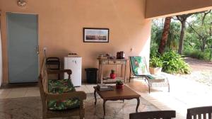a living room with chairs and a table and a refrigerator at Loft em chácara Espírito Santo in Espirito Santo Do Pinhal