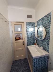 a bathroom with a sink and a mirror and a door at Memo Moscavide Guest House in Lisbon