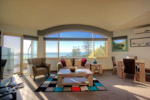 a living room with a couch and a table at Pierview Apartments in Lorne